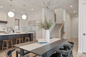 Dining room with light wood-style flooring, stairway, and recessed lighting