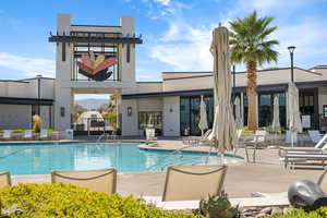 Back of property featuring a patio, a community pool, and stucco siding