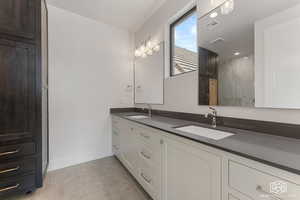 Bathroom featuring double vanity and light tile patterned floors