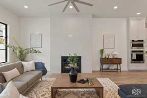 Living area featuring recessed lighting, a fireplace, light wood-type flooring, and ceiling fan