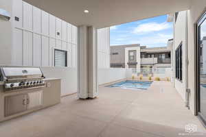 View of pool featuring a jacuzzi and an outdoor kitchen