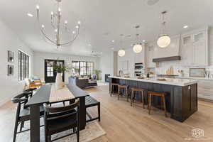 Dining room featuring a ceiling fan, light wood-type flooring, recessed lighting, and a chandelier