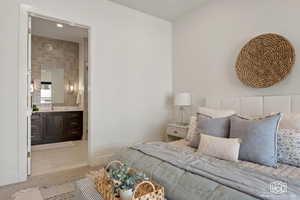 Bedroom with light tile patterned floors, connected bathroom, and recessed lighting