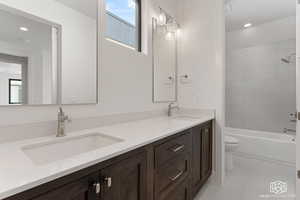 Bathroom with plenty of natural light, double vanity,  shower combination, recessed lighting, and light tile patterned floors