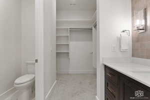 Bathroom featuring vanity and a spacious closet