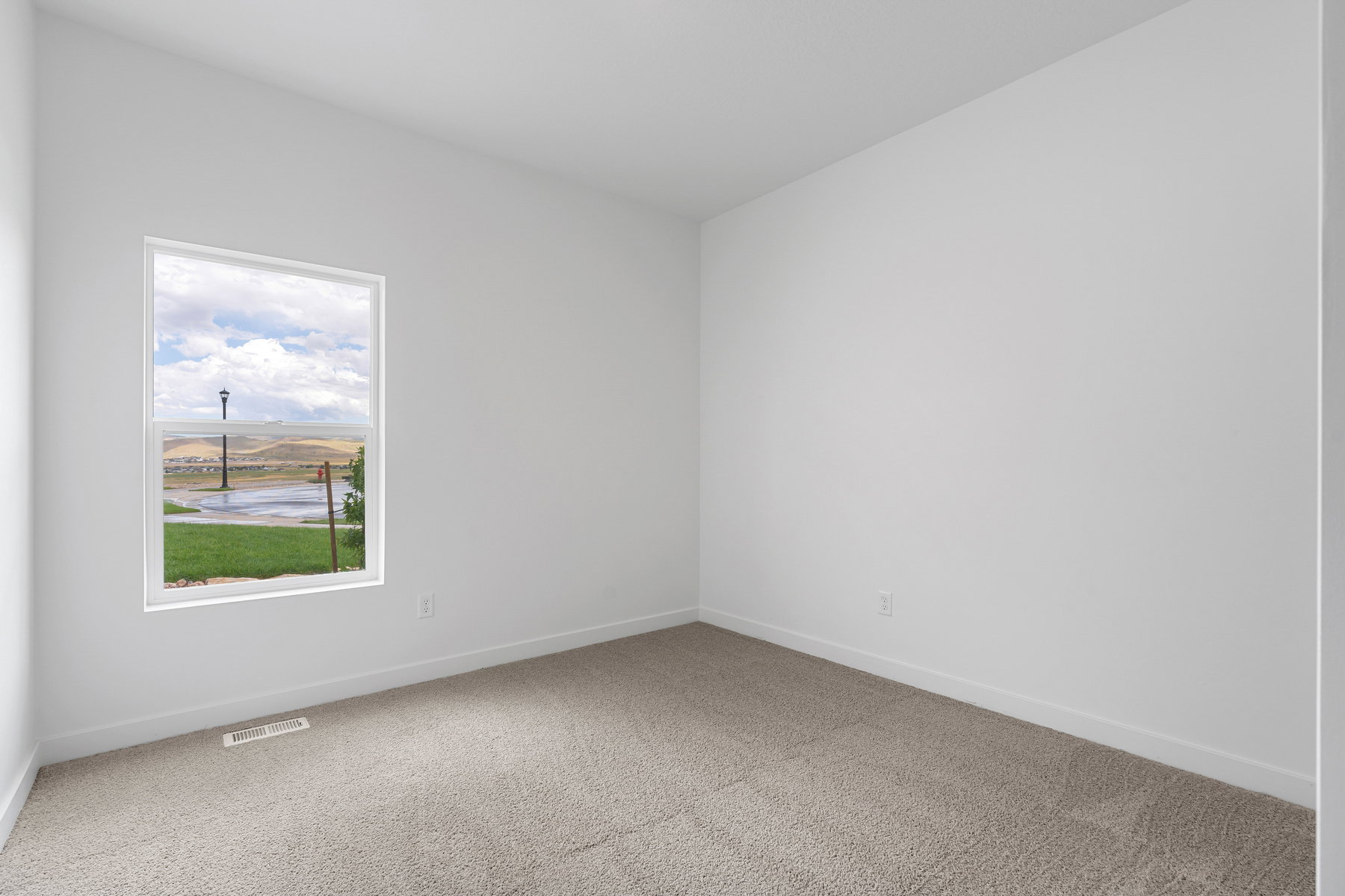 Spare room featuring light carpet and baseboards