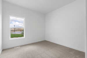 Spare room featuring light carpet and baseboards