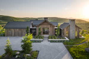 View of front of house featuring a metal roof, a chimney, a standing seam roof, and board and batten siding