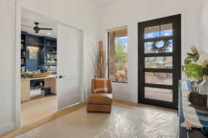 Doorway to outside featuring an office area, wood finished floors, and ceiling fan