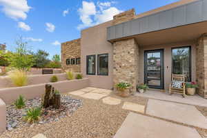 View of exterior entry with stone siding and stucco siding