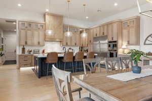 Dining area with recessed lighting and light wood finished floors