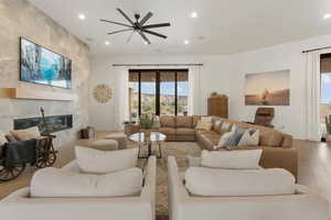 Living area with wood finished floors, recessed lighting, a fireplace, and ceiling fan