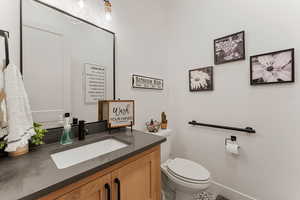 Half bathroom featuring vanity and toilet