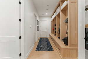 Mudroom featuring light wood-type flooring, recessed lighting, and washer / clothes dryer