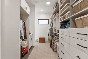 Spacious closet with light colored carpet and light tile patterned flooring