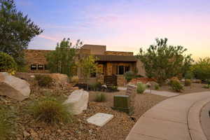 Pueblo-style home featuring stone siding and stucco siding