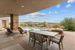 View of patio featuring a mountain view, outdoor dining area, and an outdoor fire pit