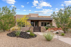 Pueblo-style home with stone siding and stucco siding