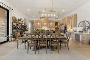 Dining room with light wood-style flooring and recessed lighting