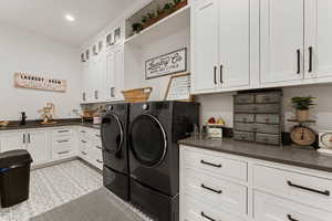 Washroom featuring cabinet space, washer and dryer, and recessed lighting