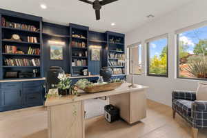 Office with light wood finished floors, a ceiling fan, and recessed lighting