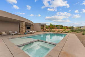 View of pool featuring a patio and a pool with connected hot tub