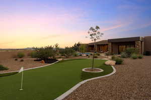 View of yard with an area to practice putting and a patio area