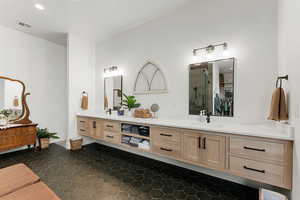 Full bath with a shower stall, double vanity, dark tile patterned flooring, and recessed lighting