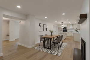 Dining room featuring recessed lighting, light wood-type flooring, and a fireplace