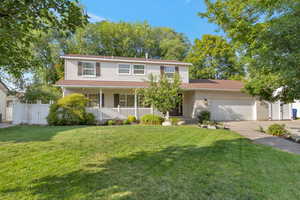 Traditional-style home featuring covered porch, an attached garage, concrete driveway, and brick siding