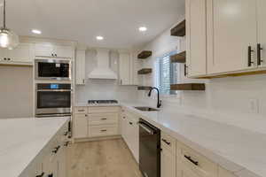 Kitchen with decorative backsplash, open shelves, light stone counters, stainless steel finishes, and recessed lighting