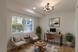 Office area featuring light wood finished floors, recessed lighting, and a chandelier