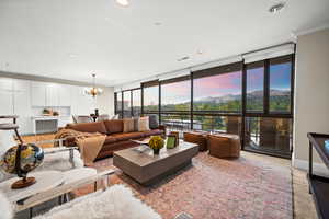 Family room featuring a wall of windows, a chandelier, recessed lighting, and light carpet