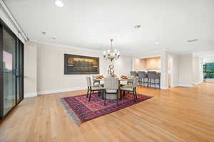 Dining room featuring a chandelier, ornamental molding, recessed lighting, and light wood-style flooring