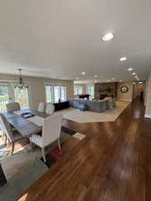 Dining area with a fireplace, wood-type flooring, a textured ceiling, and recessed lighting