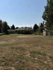 View of green lawn featuring a storage unit