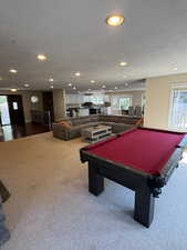 Family room featuring healthy amount of natural light, a textured ceiling, billiards table, recessed lighting, and carpet floors