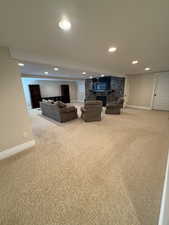 Living room featuring a fireplace, light carpet, and recessed lighting