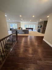 Hall with a textured ceiling, dark wood-style flooring, and recessed lighting