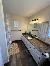 Bathroom featuring vanity, dark wood finished floors, and curtained shower