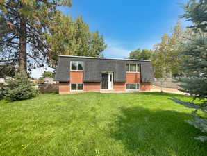 Back of property with roof with shingles, mansard roof, and brick siding