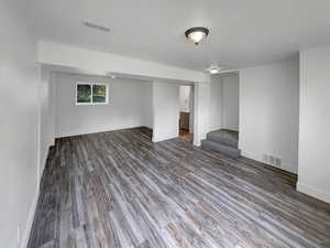 Basement with stairway and wood finished floors