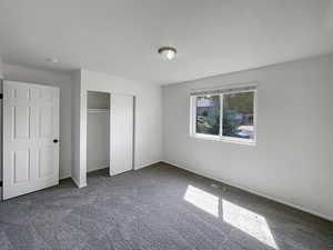 Unfurnished bedroom featuring carpet and a closet
