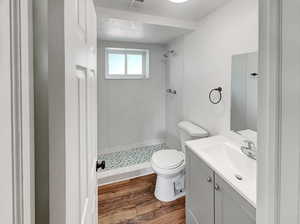 Full bathroom with a shower stall, vanity, and dark wood finished floors