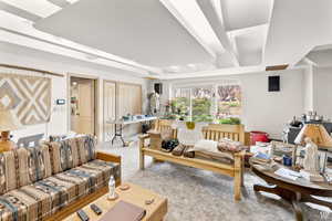 Living room featuring beamed ceiling and carpet floors