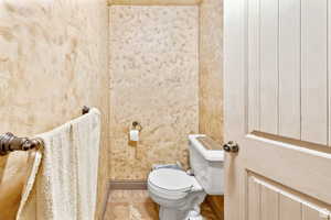 Bathroom with tile patterned floors and wallpapered walls