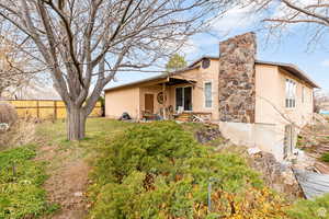 View of front of property featuring stucco siding, a chimney, and a patio area