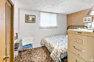 Bedroom featuring a textured ceiling and light carpet