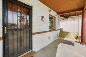 Property entrance featuring brick siding