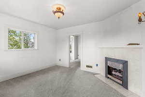 Unfurnished living room featuring a fireplace and carpet floors